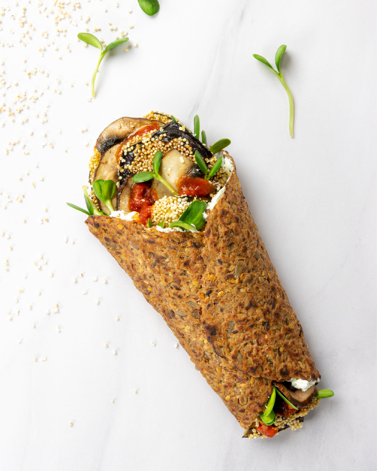 Primal Bakery Multigrain Protein Wrap filled with mushrooms, greens, cheese, and vegetables.